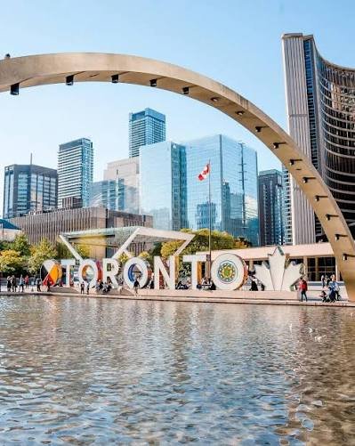 The Toronto sign at Nathan Phillips Square with City Hall behind it